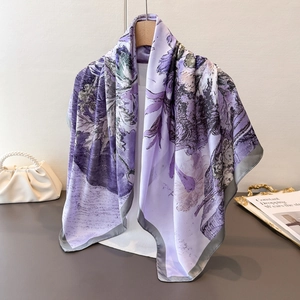 Close-up of elegant lavender floral silk scarf with smooth satin edges on a hanger
