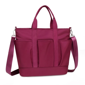 Magenta nylon tote bag with multi-pocket design and adjustable crossbody strap