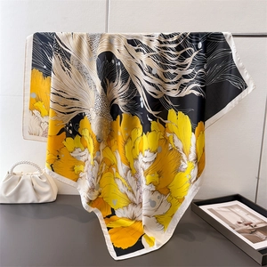 Artistic goldfish and flower silk scarf in yellow black and white hanging on a rack