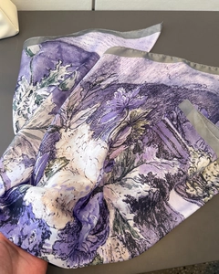Detail of elegant purple lily floral print on satin scarf with refined grey borders