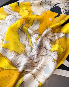 Macro detail of yellow silk scarf with white floral prints and koi fish patterns