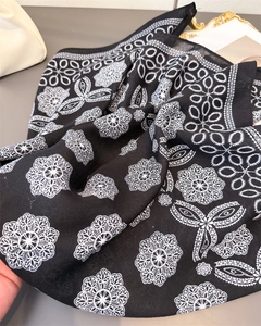 Detail of black cotton-linen scarf featuring white mandala floral and geometric patterns
