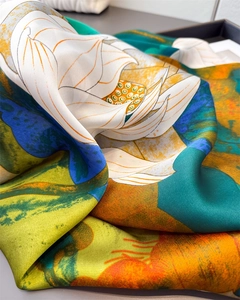 Close-up of silk-textured scarf showing white lotus pattern and smooth fabric texture