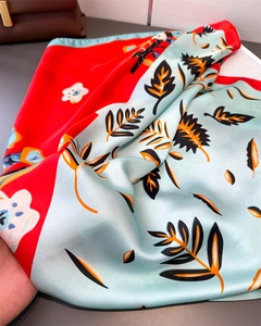 Detail of printed silk square scarf with vibrant floral patterns and satin texture
