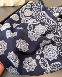 Detail of dark blue scarf with white mandala patterns and fine twill fabric texture