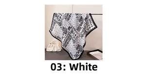 Dettaglio di un foulard bianco effetto lino con motivo paisley e bordi neri rifiniti