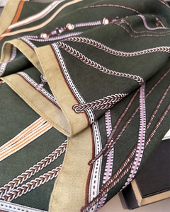 Detail eines Vintage-Reiterschals mit Seidentextur und Kettenmuster in Dunkelgrün und Gold