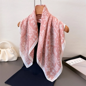 Sciarpa artistica in cotone e lino rosa con motivo paisley appesa a una gruccia in legno