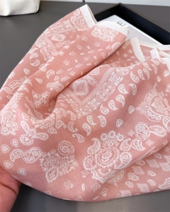 Dettaglio di sciarpa in cotone lino rosa con motivo paisley e cuciture sottili sui bordi