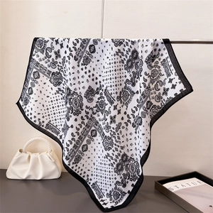Dettaglio del motivo paisley vintage su foulard bianco e nero con borsa di perle