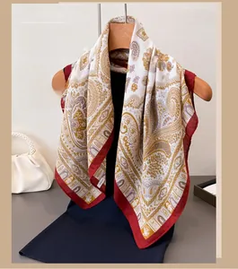 Dettaglio del motivo paisley vintage su sciarpa beige con bordi a contrasto rossi