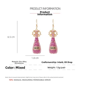 Detail view of pink rhinestone champagne bottle earrings with size 6.5cm height and cheers text