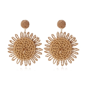 Handmade raffia sunflower drop earrings in bohemian style on a white background