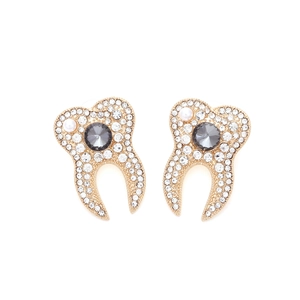 Détail macro de boucles d'oreilles dents uniques avec pavé de cristaux et petite perle