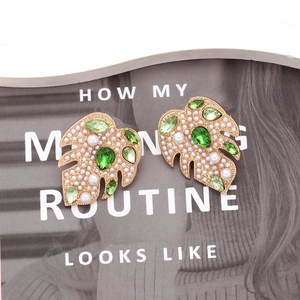 Elegant gold monstera leaf earrings with green crystals and white faux pearls