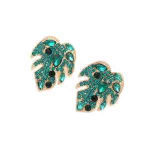 Detailed macro view of gold monstera leaf earrings with green crystals and black gems