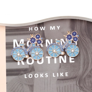 Detailed macro of bicycle earrings with blue enamel flowers and sparkling crystals