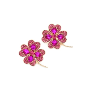Détail de boucles d'oreilles trèfle avec strass roses et monture en métal doré