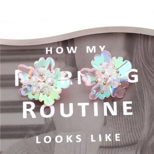 Boucles d'oreilles fleurs irisées avec cristal sur fond de magazine tendance