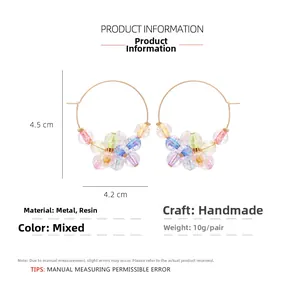 Detail view of colorful beaded hoop earrings with size measurements and resin floral accents