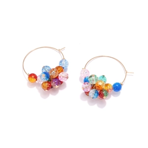 Detailed view of colorful crackle glass beads on golden bohemian style hoop earrings