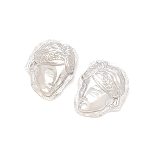 Close-up of vintage silver portrait relief earrings with detailed classical art carving
