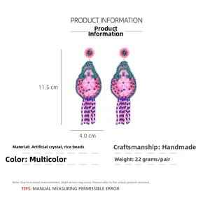 Détail de boucles d'oreilles fleuries faites main montrant les dimensions de 11,5 cm de haut