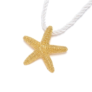 Minimalist gold starfish pendant necklace with textured finish on a white twisted rope