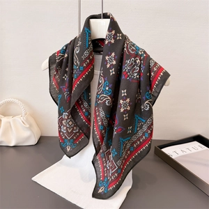Foulard vintage grigio scuro con motivo paisley esposto su una gruccia bianca