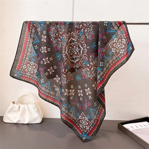 Elegante foulard di seta nero con stampa mandala colorata appeso a un supporto
