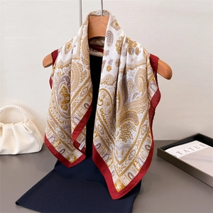 Elegante foulard in avorio con motivo paisley e bordi rosso scuro su gruccia in legno