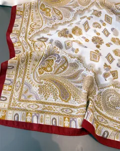 Dettaglio della fantasia paisley e del bordo rosso su questo elegante foulard di seta