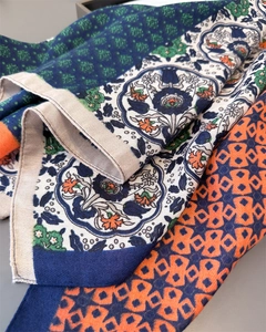 Détail macro du foulard aspect lin montrant des motifs floraux damassés et géométriques
