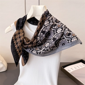 Détail d'un foulard en soie vintage avec motifs géométriques et fleurs rétro