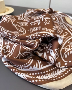 Detailed view of caramel silk scarf featuring paisley patterns and soft satin texture