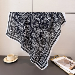 Detail of paisley print silk scarf hanging gracefully with elegant satin finish texture