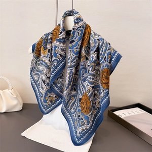 Elegant paisley and rose print scarf in navy blue and orange on a white mannequin