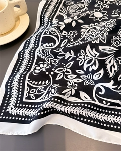 Macro view of black and white paisley print silk scarf with fine rolled edge detailing