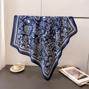 Close-up of lightweight navy paisley silk scarf draped elegantly on a display stand