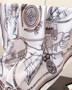Detail of nautical print silk scarf featuring anchors, sailboats, and crests on white