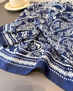 Close-up of luxury navy blue silk-like paisley scarf with intricate white floral patterns