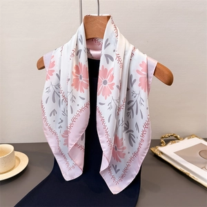 Eleganter Seidenschal mit Blumenmuster in Weiß und Rosa auf einem Holz Kleiderbügel hängend