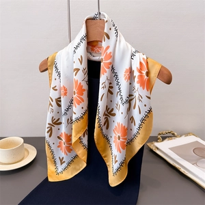 Seidiges quadratisches Tuch mit Orangenblüten und gelbem Rand an einem Holzkleiderbügel