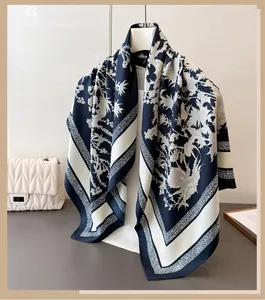 Detail view of navy and cream floral silk scarf with geometric border and satin texture