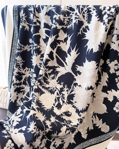 Detailed close-up of dark blue silk scarf featuring realistic thistle floral patterns