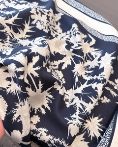Macro view of navy silk scarf with elegant floral patterns and a satin texture finish