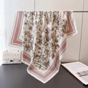 Detail of silk-like square scarf with floral prints and pink striped borders