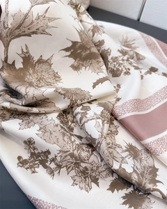 Close-up of silk scarf with floral thistle print and elegant pink striped borders