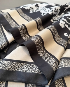 Detail shot of silk scarf showing twill texture and elegant black white floral pattern