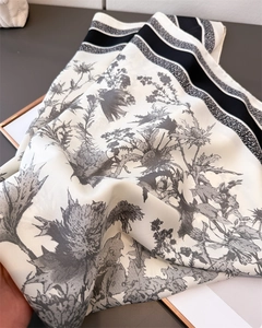Close-up of black and white thistle floral print on premium silk-like satin scarf